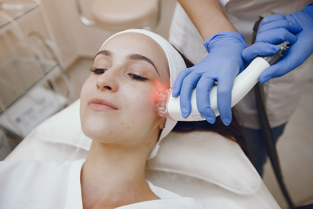 A young woman is undergoing red light therapy treatment.