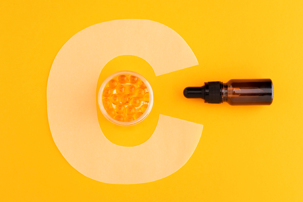 Vitamin C serum dropper bottle with a close-up of food supplements.