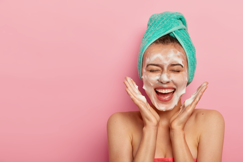 Happy joyous young girl doing her face wash.