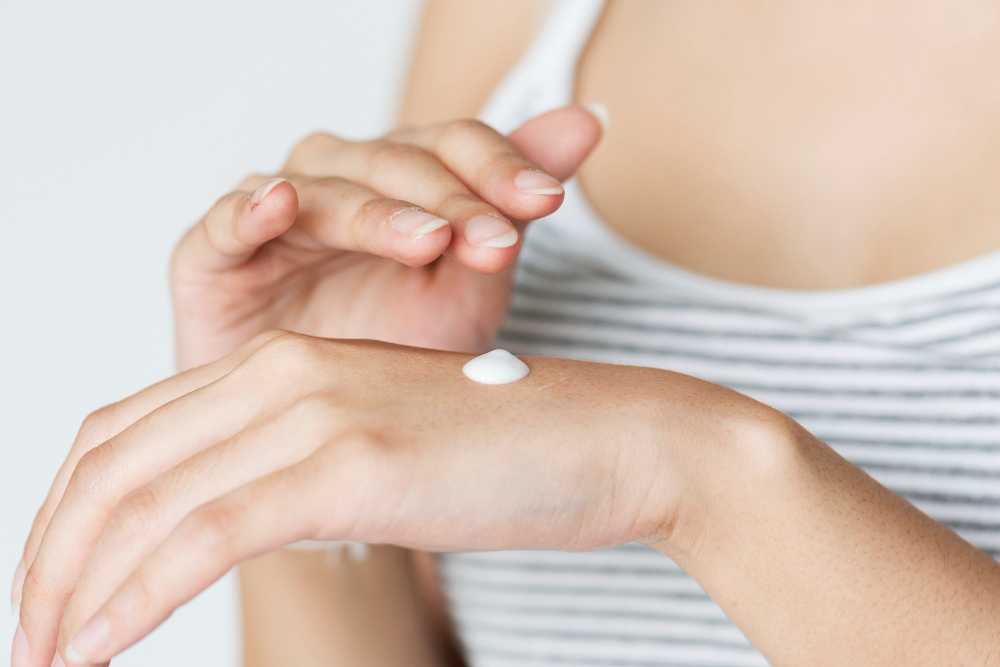 Women applying Vaseline body lotion on her hand.